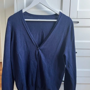 Mörkblå kofta från Anna Field💙🦋 - Säljer en mörkblå kofta från Anna Field med v-ringning och en knapp framtill. Perfekt att slänga över en topp eller klänning. Tunn och mjuk i materialet, långärmad och enkel i modellen.