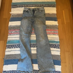Ljusblå bootcut jeans - Säljer ett par ljusblå jeans med bootcut-modell. Klassisk femficksdesign och normal passform. Jeansen har en snygg tvättad look och är tillverkade i jeansmaterial. 