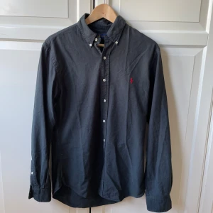 Mörkblå skjorta från Ralph Lauren - Säljer en mörkblå långärmad skjorta från Ralph Lauren. Mycket bra skick och storlek M. Hör av er vid intresse!!