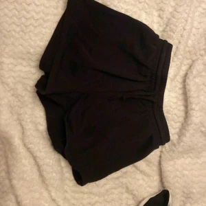 Svarta shorts från H&M - Svarta shorts från H&M med resår och dragsko i midjan. Klassisk modell i mjukt material, perfekta för avslappnade dagar eller träning. Enkla och stilrena utan synliga mönster eller detaljer.