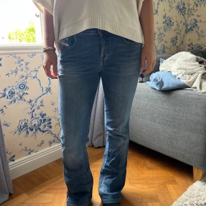 Blå bootcut jeans med normal passform - Snygga blå jeans med bootcut-modell och klassisk femficksdesign. Jeansen har normal passform och är tillverkade i ett mjukt denimtyg som sitter skönt. Perfekta för dig som gillar en tidlös look med lite utsvängda ben.