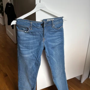 Bootcut jeans i ljusblå denim - Säljer ett par  jeans i ljusblå denim med bootcut passform. Jeansen har fem fickor, normal midja och snygga slitningar framtill. Perfekta för dig som gillar en tidlös look med lite utsvängda ben. 