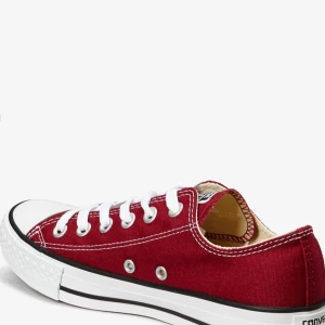 Röda Converse sneakers i canvas - Klassiska röda Converse sneakers med vit tå och sula. Skorna har vit snörning, lågt skaft och tydliga kontrastsömmar. Tillverkade i canvas med gummisula och rund tå. Perfekta för dig som gillar en tidlös och avslappnad stil. Köpte för en tag sen och lite slitna, se bild 3/4.