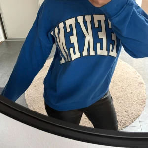 Blå sweatshirt med WEEKEND-tryck -  Materialet känns som bomull och passformen är normal. Mjuk mot kroppen i invändigt, allmänt skönt tröja. 