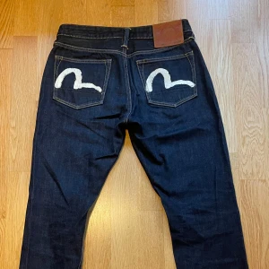 Evisu jeans 29x34 - Kvitto finns. Mörkblå jeans från Evisu med klassisk vit målad logga på bakfickorna. Använda fåtal gånger. Nypris 2850kr beställt från zalando. 