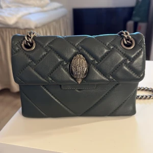 Quiltad grön axelväska från Kurt Geiger - Snygg quiltad axelväska i mörkgrönt skinn från Kurt Geiger. Perfekt storlek för det viktigaste och stängs med magnetknapp 💞