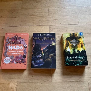 Populära böcker från Akademibokhandeln  - Tre populära böcker för unga: Hilda och den stora paraden (äventyr och humor), Harry Potter and the Philosopher's Stone (magisk fantasyklassiker), och Stad av skuggor (spännande urban fantasy). Perfekt för dig som gillar magi, äventyr och starka karaktärer! Säljer alla för 200kr. Köparen står för frakt 📦 