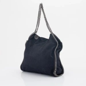 Svart Axelväska Från Stella McCartney - Snygg svart axelväska från Stella McCartney 🖤Med kedjedetaljer längs kanterna och som axelrem. Perfekt för dig som vill ha en stor väska med mycket utrymme och som är stilren med coola detaljer till!Perfekt som skolväska eller till jobbet du bestämmer! 