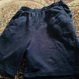 Mörkblå shorts från Pull&Bear - Mörkblå shorts från Pull&Bear i mjuk bomull med elastisk midja och sidfickor. Klassisk och enkel design, perfekt för chill dagar eller när du vill ha det bekvämt. Modellen är rak och har en loose passform.
