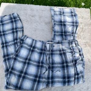 Rutig mjukisbyxa med snörning XL - Blå och vita rutiga mjukisbyxor från 157 i storlek XL. Byxorna har elastisk midja med snörning och är tillverkade i mjukt bomullstyg. Perfekta för chill dagar hemma eller när du vill vara extra bekväm.