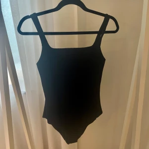 Svart baddräkt med djup rygg från COS storlek 36 - En stilren svart baddräkt från COS. Storlek 36. Jättebra skick, knappt använd endast provad.