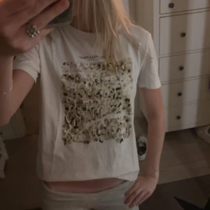 Vit t-shirt med leopardmönster - Snygg vit t-shirt med ett stort leopardmönstrat tryck framtill i beige, svart och guldiga toner. Klassisk passform med korta ärmar och rund halsringning. Perfekt för dig som vill sticka ut lite extra med ett coolt print. Skriv för fler bilder