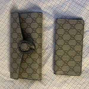 Kuvertväska och plånbok monogram - Säljer en snygg kuvertväska och matchande plånbok  med klassiskt GG-monogram i beige och brunt. Väskan har ett coolt spänne med ormdetalj i metall och insidan har flera kortfack. Perfekt för dig som gillar lyxiga accessoarer med ikonisk design.