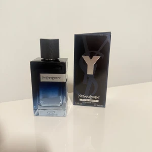 Yves Saint Laurent Y EdP 100ml - Yves Saint Laurent Y Eau de Parfum i en snygg, mörkblå glasflaska med silverdetaljer och metallock. Flaskan rymmer 100 ml och har en stilren, maskulin design. Kommer med originalkartong i matchande färg och stor Y-logga framtill.