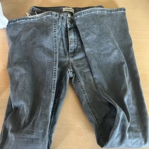 Grå jeans från ONLY - Snygga grå jeans från ONLY med klassisk femficksdesign och dragkedja. Jeansen har en rak passform och är tillverkade i mjukt denimtyg som ger en avslappnad vibe. Perfekta till sneakers eller boots.