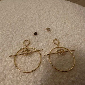 Guldörhängen från Dior - Snygga guldörhängen i cirkelform med unika pärldetaljer och en tvärgående stav. Perfekta för att ge en elegant touch till din outfit. De har en modern design som verkligen sticker ut.