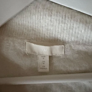 Vit tröja från H&M - Säljer en mysig vit tröja från H&M. Tröjan har en enkel design med långa ärmar och är perfekt för kyligare dagar. Den är tillverkad i ett mjukt material som känns skönt mot huden.