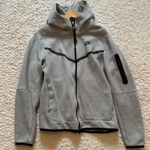 Grå Nike tech fleece - Snygg grå nike tech fleece, endast använd ett par gånger. Storlek: M. Skick 8/10. Nypris: 2000kr. Mitt pris: 599kr.
