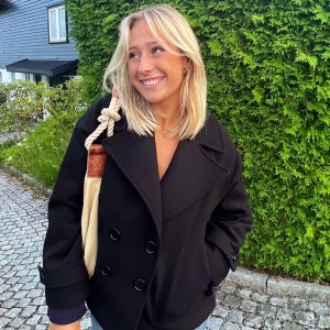 Svart kappa med knappar - Säljer nu min snygga svarta kappa med dubbelknäppning och bred krage från Design by si. Passar perfekt för både höst och vår. Skriv för fler bilder. Nypris 760kr 