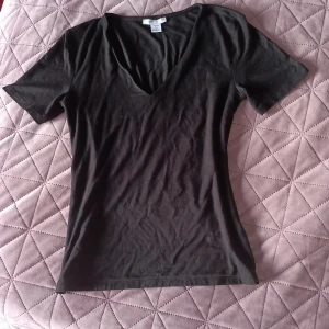 En söt ☺️ svart v-ringad topp från Amisu - Säljer en stilren svart v-ringad topp från Amisu. Toppen har korta ärmar och en tight passform, perfekt för en enkel och snygg look. Tillverkad i ett mjukt och bekvämt material !👚🤩