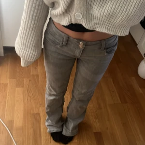 Grå bootcut jeans - Snygga grå bootcut jeans med låg midja. De har en klassisk femficksdesign och en knappgylf. Perfekta för en avslappnad stil.