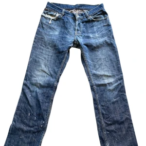 Blå jeans med slitna detaljer - Blå lowwaist jeans med snygga detaljer på fickorna och benen! En slitning på höger ficka!💕  Midja mätt platt: 36 cm                                                Innerbenslängd: 71cm (ungefär)                                Grenen: 19,5 cm                                                           Priset går alltid att diskuteras. Skriv om frågor finns!💕