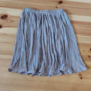 Silvrig kjol - Säljer en glittrig silver kjol med plisserad design. Kjolen har en elastisk midja för bekväm passform och är perfekt för att lysa upp vilken outfit som helst✨️ Passar perfekt till fest eller fina tillställningar🥰