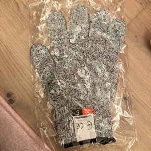 Skyddshandskar för matlagning och hantverk - Skyddar handen mot skärskador och rivskador. Skyddar effektivt mot skär- och rivskador Passar både höger- och vänsterhänta Mjuk och bekväm Multifunktionella skärskyddshandskar som skyddar din hand mot skärsår och rivsår när du arbetar i köket. Perfekt att använda vid t.ex. matlagning när du ska hacka, skiva, skära eller riva olika ingredienser eller öppna skaldjur. Skyddshandsken är motståndskraftig mot skärsår upp till kategori 5