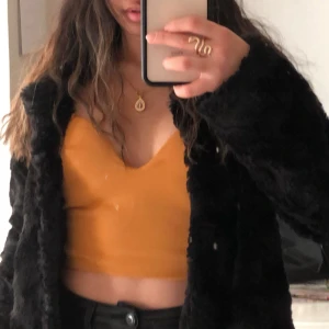 Gul tubtopp från Aora Brand - Snygg gul tubtopp från Aora Brand med dragkedja bak. Perfekt för en festlig look. Har klippt bort bandet vilket gör att toppen är axelbandslös.