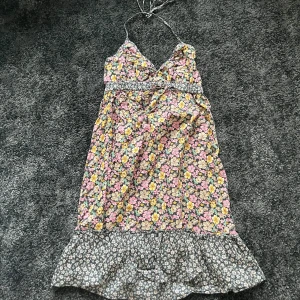 Blommig klänning - Säljer en söt blommig klänning från H&M med v-ringning och knytband i nacken. Storlek 38, säljer för 160💗