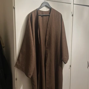 Öppen abaya - Säljer en stilren brun öppen abaya med lång passform och vida ärmar. Perfekt för höst och vår. Den har en öppen design