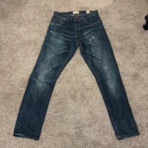 Blå jeans från Jack and Jones - Snygga blå jeans från Vintage Clothing med klassisk femficksdesign och slitna detaljer. De har en rak passform och är tillverkade i slitstarkt denim. Perfekta för en avslappnad stil. Skriv till mig om du har några frågor 