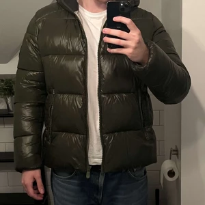 Save The Duck Puffer Jacket - Säljer denna snygga gröna puffer jackan från Save The Duck! Jackan är sällan använd och är i ett mycket bra skick, inga deffekter eller liknande. Jackan är i storleken XL, men passar L utmärkt. Hör gärna av dig för frågor eller liknande!