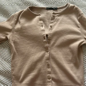 Beigebrun kofta från Lager157 - PRIS GÅR ATT DISKUTERA!! Säljer en stilren beige kofta från Lager157. Den har knappar framtill och har långa ärmar, perfekt för lager-på-lager. Passar bra till både jeans och kjol. Funkar när som! 💗💗HELT SLUTSÅLD SÅ PASSA PÅ!!