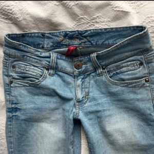 Lågmidjade bootcut jeans  - Super snygga ljusblå, Lågmidjade bootcut Jeans. Jätte fint skick, säljer då de tyvärr är lite förstora. Glittriga!