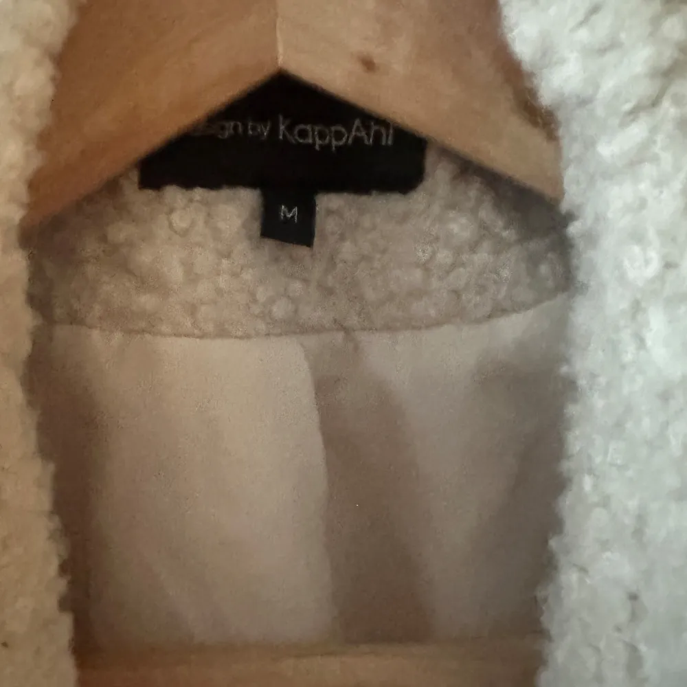 Säljer en mysig beige teddyjacka från KappAhl. Jackan har en klassisk design med bred krage och är perfekt för kyliga dagar. Den är långärmad och har en mjuk, fluffig yta som ger en trendig look.. Takit.