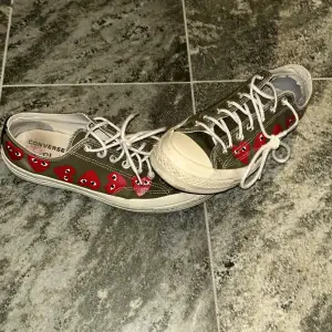 Säljer ett par gröna Converse med unika röda hjärtan längs sidan. Skorna har klassisk snörning och en vit sula. Perfekta för dig som vill ha en cool och avslappnad stil. Tveka inte på att kontakta mig vid minsta fundering. Ord pris ca 1000kr mot pris 350