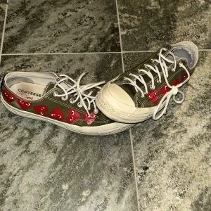 Converse skor - Säljer ett par gröna Converse med unika röda hjärtan längs sidan. Skorna har klassisk snörning och en vit sula. Perfekta för dig som vill ha en cool och avslappnad stil. Tveka inte på att kontakta mig vid minsta fundering. Ord pris ca 1000kr mot pris 350