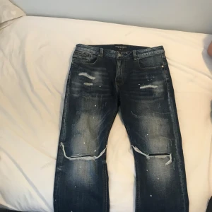 Blå jeans med slitningar från Suply demand - Har använt få tal gånger och har ej skador eller är i dåligt skick jag köpte dem för 600kr och har en mzkenzie tröja mörk blå och vit som passar perfekt till jeansen som jag skulle kunna skicka med om man köper jeans också så man får en tröja och byxor 700 med jeans och mzkenzie tröja skriv för frågor så skickar jag bild på tröjan också 