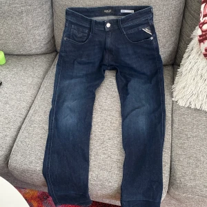 Mörkblå jeans från Replay - Snygga mörkblå jeans från Replay, modell Anbass med slim fit. Klassisk femficksdesign och tillverkade i ett bekvämt denimtyg. Perfekta för en stilren look. Dom är som ny har haft på mig dom typ 5 gånger passar inte priset kom gärna med pris förslag😁