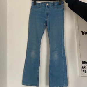 Blå flare jeans från H&M - Säljer ett par snygga blå flare jeans från H&M. De är mid waist och justerbar midja för perfekt passform. Klassisk femficksdesign med knapp och dragkedja framtill. 