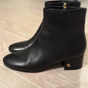 Lauren Ralph LaurenEldridge Burnished Leather Boot - Kängor strl:38 - Snygga svarta boots i skinn från Lauren Ralph Lauren med dragkedja och låg klack. Perfekta för en stilren look med en diskret logga på hälen. Passar till många olika outfits och tillfällen.