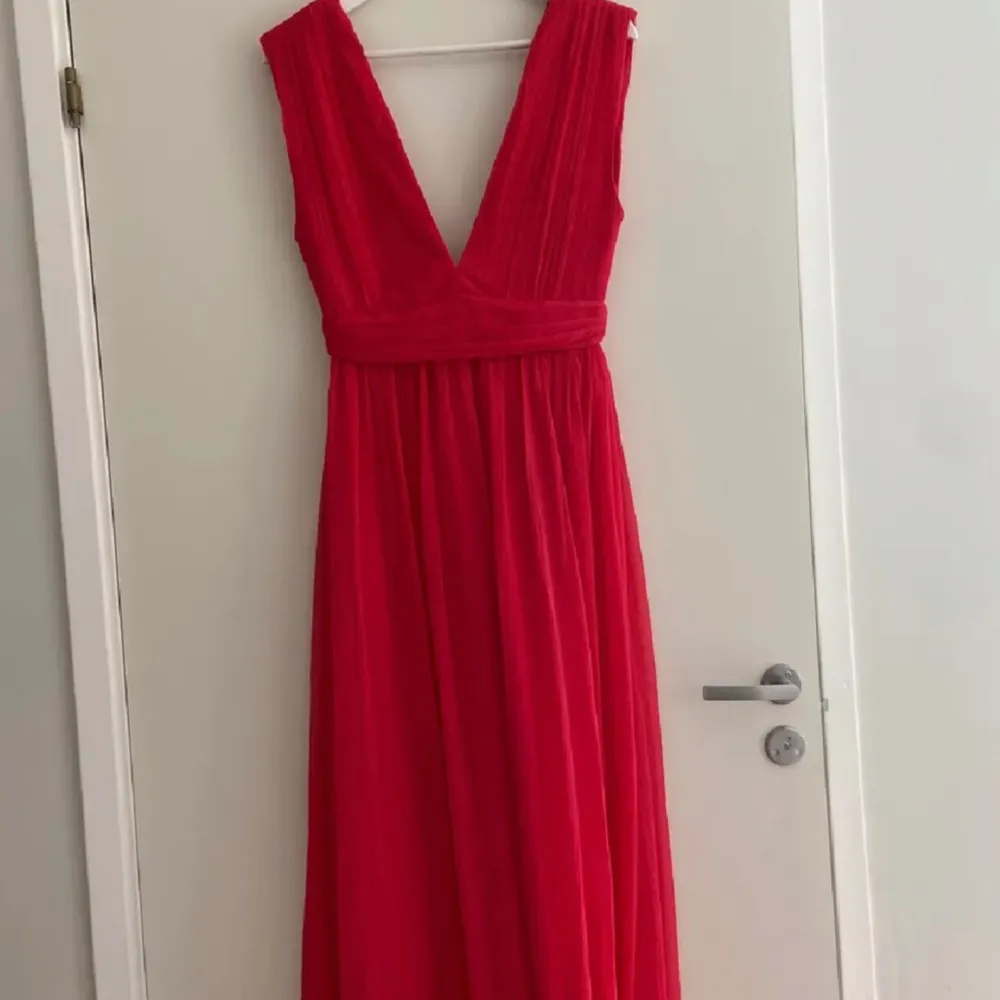 Röd långklänning med djup v-ringning och ärmlös design ❤️. Mekot.