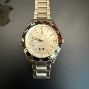 Silverfärgad Hilfiger herrklocka - Fet Tommy hilfiger klocka som är i nyskick. Säljer den pga den aldrig har kommit till användning. Batteriet är dock ur funktion men det gär fort att lösa. Pris kan diskuteras vid snabb affär. Perfekt accessoar för dig som gillar klassisk design.