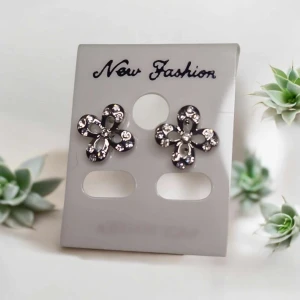 Blommiga örhängen med strass - Snygga örhängen i form av blommor med glittrande strassdetaljer. De är i silverfärg och har en öppen blomform som ger en cool och trendig look. Perfekta för att ge din outfit lite extra bling.