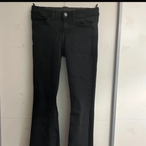 Svarta bootcut jeans - Svarta jeans med bootcut-modell och klassisk femficksdesign. Byxorna har normal midja och raka ben som blir vidare nedtill. Perfekta för dig som gillar en tidlös och clean look. Passar till allt och är lätta att styla.