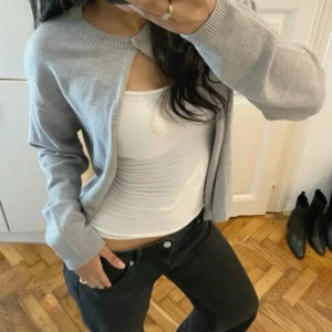 Grå kofta från Gina Tricot XS - Superfin ljusgrå kofta från Gina Tricot i storlek XS. Koftan har rund halsringning, ribbade kanter och stängs med en knapp upptill. Perfekt att slänga över ett linne eller t-shirt. Mjuk och skön, passar till allt. Nypris 399💞