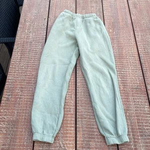 Grå mjukisbyxor från Gina Tricot XXS - Snygga ljusgrå mjukisbyxor från Gina Tricot, basically basics-kollektionen. De har resår i midjan och vid bensluten för en chill och bekväm passform. Perfekta för en avslappnad stil och supermjuka i bomullsmaterial.