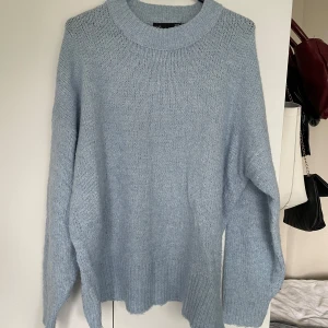 Ljusblå stickad oversized tröja - Supermysig ljusblå stickad tröja med oversized passform och bred ribbad kant vid halsen. Storlek S men passar även M