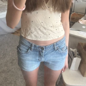 Ljusblå lågmidjade jeansshorts  - Säljer ett par lågmidjade ljusblå jeansshorts med snyggt blommigt broderi på bakfickan. Perfekta för sommaren💕 midjemåttet är 39cm och shortsen är från esprit